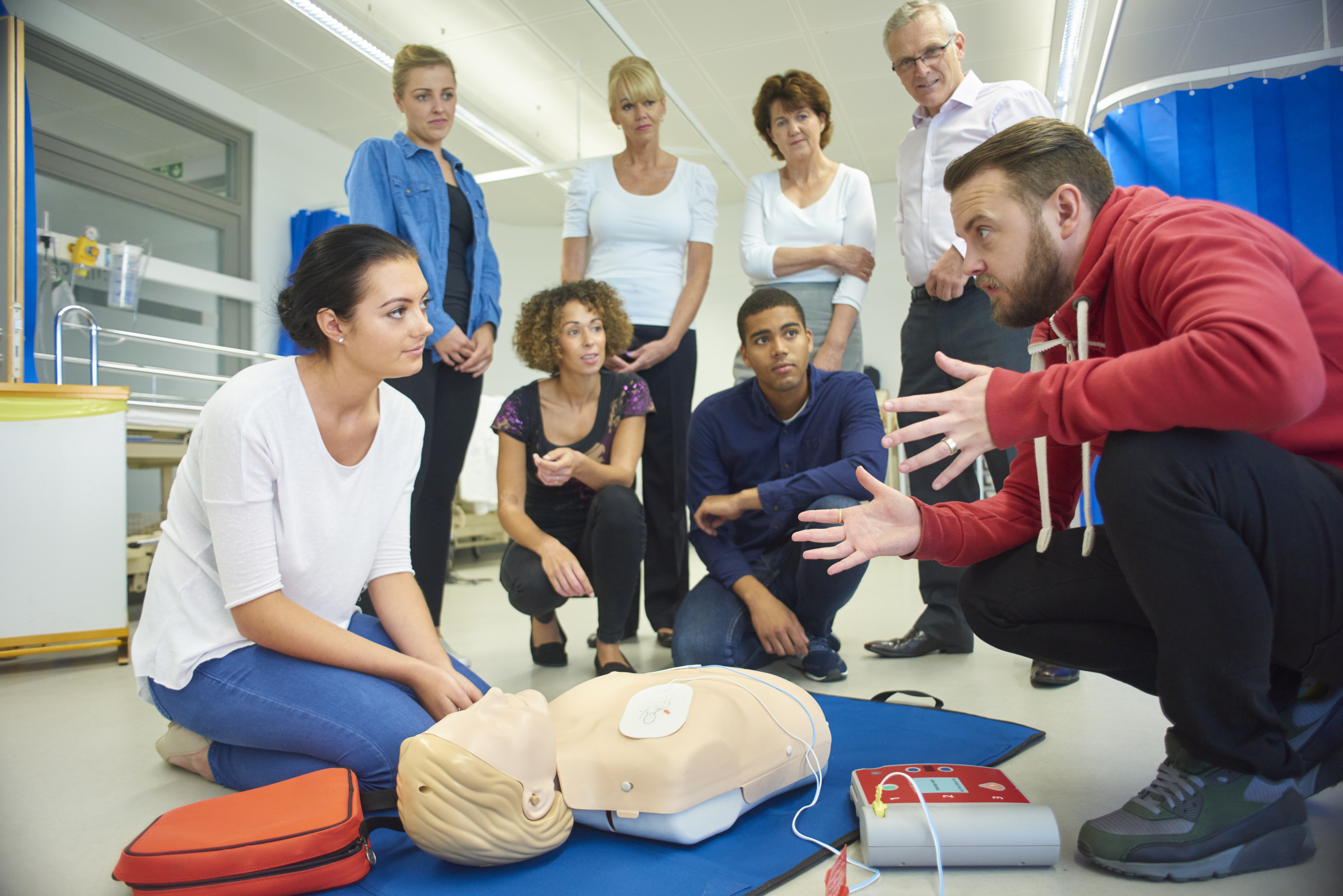 group of men and women taking a CPR class